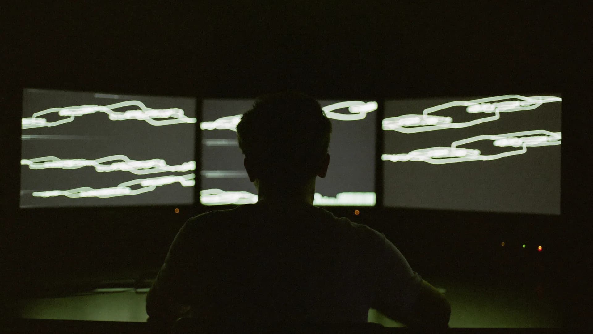 A darkened operations room lit only by dashboards